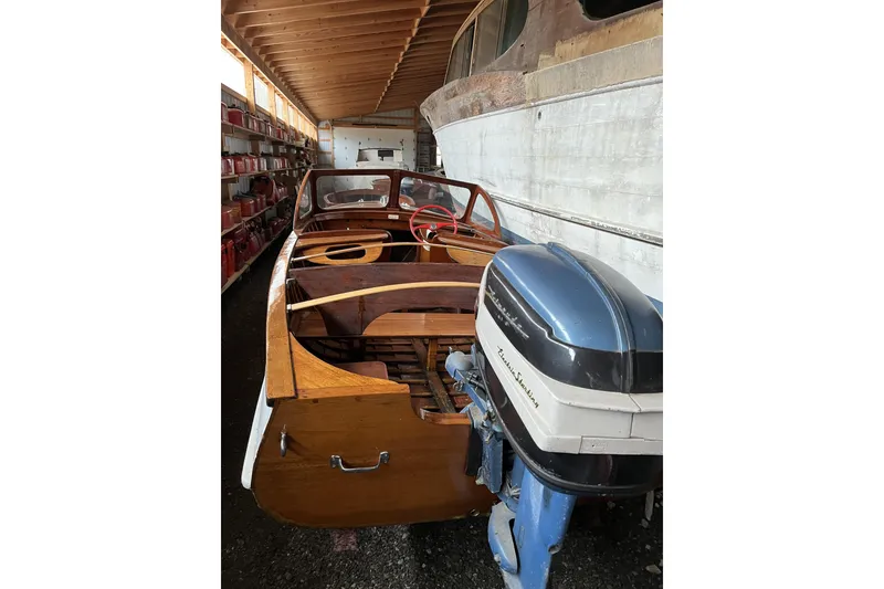 Slide: The Image of 1954 Lyman outboard boat with wooden interior and vintage motor in storage. - 8
