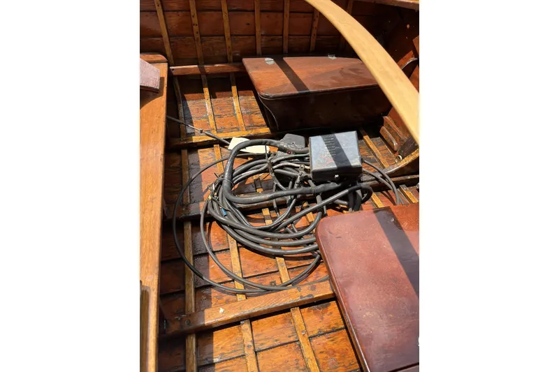 Slide: The Image of 1954 Lyman outboard boat interior with wooden seats and coiled cables. - 9
