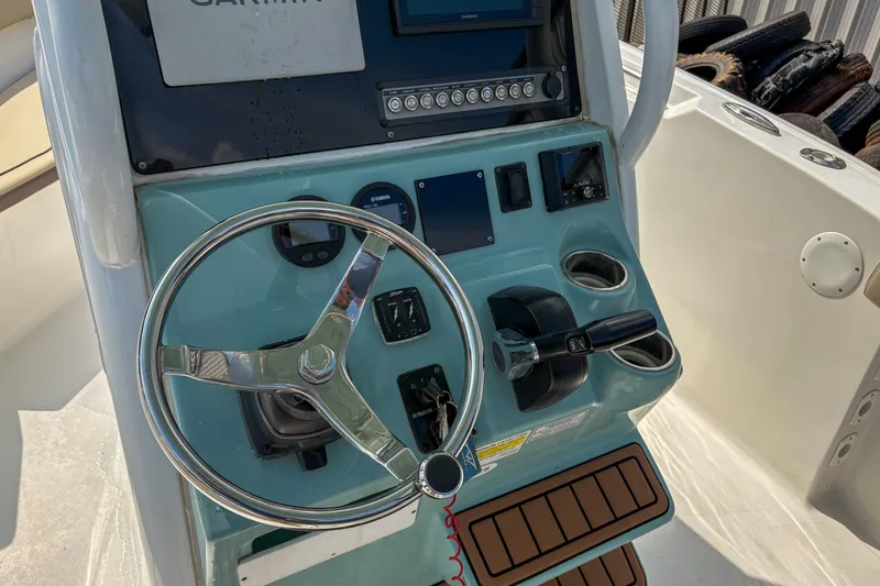Slide: The Image of 2020 Tidewater 232 CC Adventure boat console with steering wheel and controls. - 10