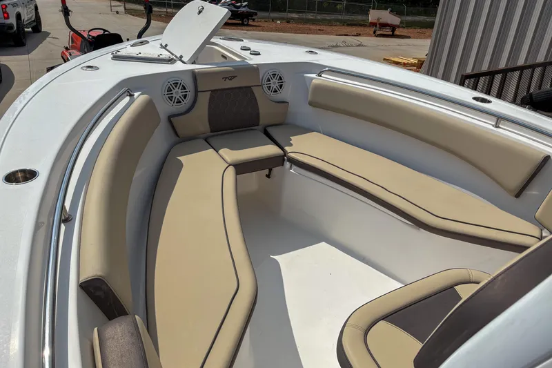 Slide: The Image of 2020 Tidewater 232 CC Adventure boat interior with beige seating and speakers. - 11