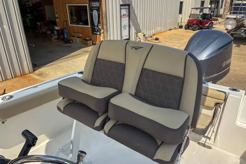 Slide: The Image of 2020 Tidewater 232 CC Adventure boat seats with Yamaha engine in a marina setting. - 9