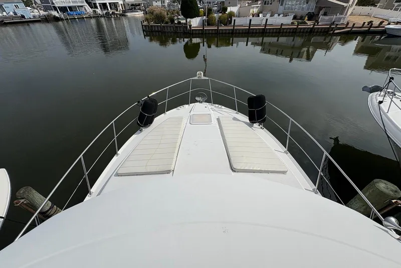 Slide: The Image of 2002 Carver 406 Aft Cabin Motor Yacht docked in a serene marina setting. - 13