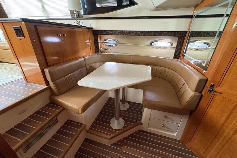 Slide: The Image of 2002 Carver 406 Aft Cabin Motor Yacht interior with cozy dining area and leather seating. - 19