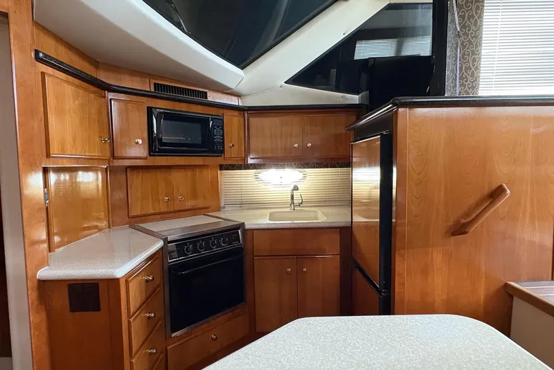 Slide: The Image of 2002 Carver 406 Aft Cabin Motor Yacht kitchen with wood cabinetry and modern appliances. - 20