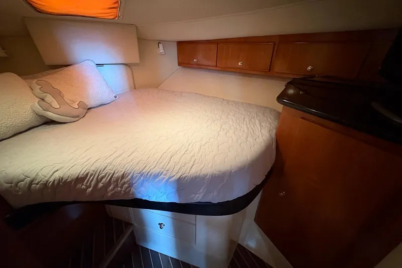 Slide: The Image of Cozy bedroom in 2002 Carver 406 Aft Cabin Motor Yacht with wood cabinets and plush bedding. - 22
