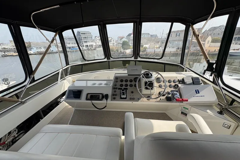 Slide: The Image of 2002 Carver 406 Aft Cabin Motor Yacht helm with steering wheel and navigation controls. - 6
