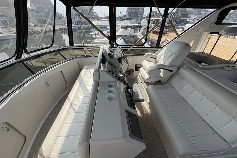 Slide: The Image of 2002 Carver 406 Aft Cabin Motor Yacht helm with leather seating and panoramic windows. - 8