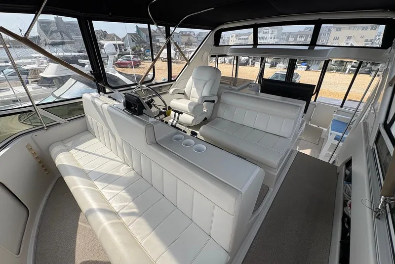 Slide: The Image of 2002 Carver 406 Aft Cabin Motor Yacht interior with white seating and helm station. - 9