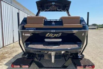 Slide: The Image of 2026 Tigé 24RZX boat, rear view, parked outdoors, showcasing sleek design and branding. - 4