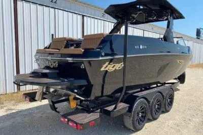 Slide: The Image of 2026 Tigé 24RZX boat on trailer, sleek black design, parked outdoors. - 5