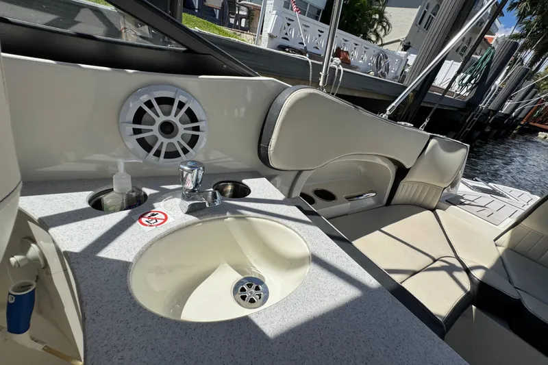 Slide: The Image of 2021 Stingray 231 DC boat interior with sink, speaker, and seating area. - 11