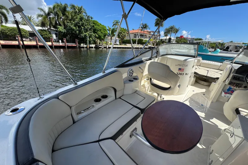 Slide: The Image of 2021 Stingray 231 DC boat interior with seating, table, and waterfront view. - 8