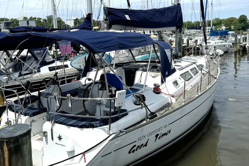 Slide: The Image of 2005 Jeanneau Sun Odyssey 40.3 sailboat docked, aerial view, blue canopy, calm waters. - 2