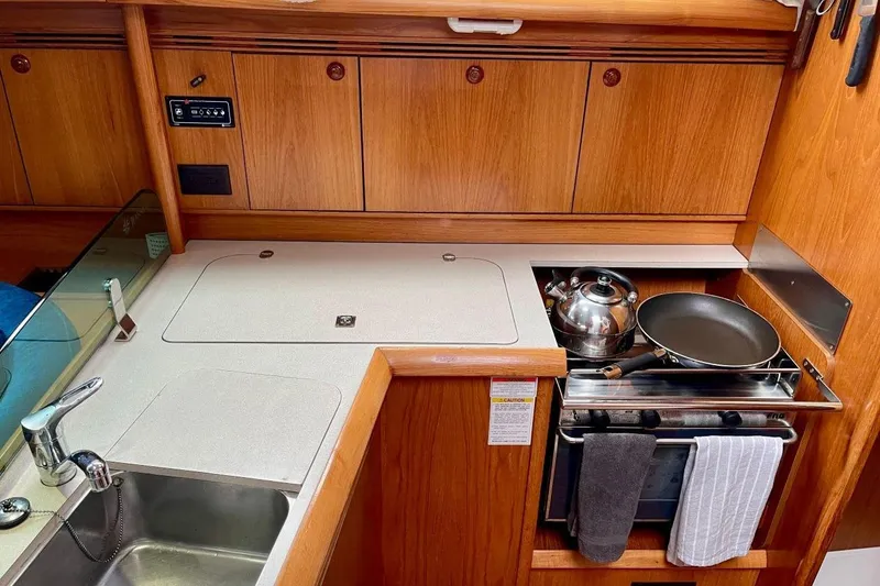 Slide: The Image of Jeanneau Sun Odyssey 40.3 yacht kitchen with stove, sink, and wooden cabinetry, 2005 model. - 27