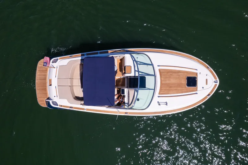 Slide: The Image of 2007 Chris Craft Corsair boat on water, aerial view, with American flag. - 17