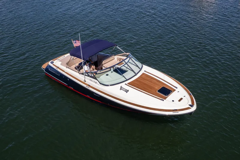 Slide: The Image of 2007 Chris Craft Corsair boat on water, featuring sleek design and American flag. - 18