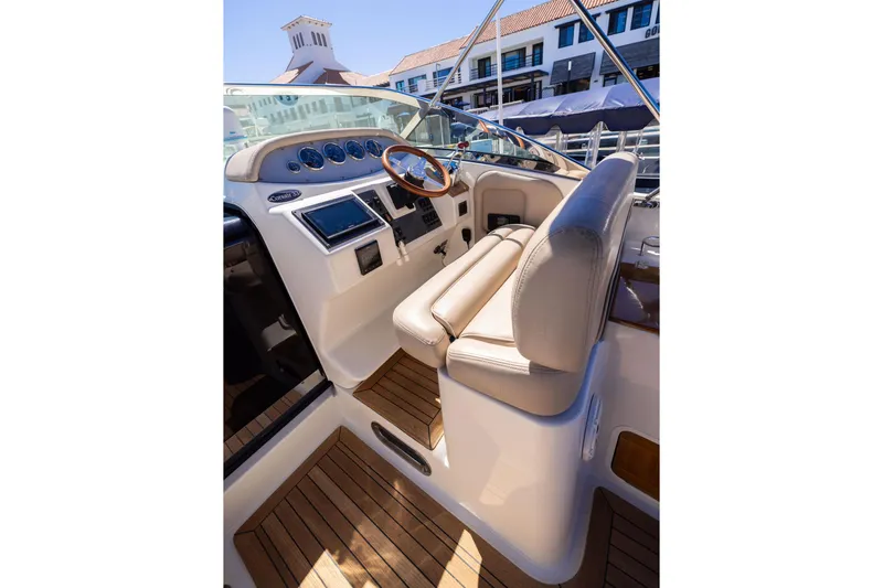 Slide: The Image of 2007 Chris Craft Corsair boat interior with leather seating and wooden steering wheel. - 2