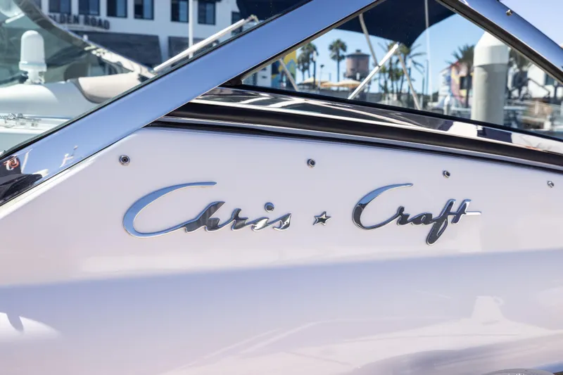 Slide: The Image of 2007 Chris Craft Corsair boat with chrome logo, docked in a sunny marina. - 21