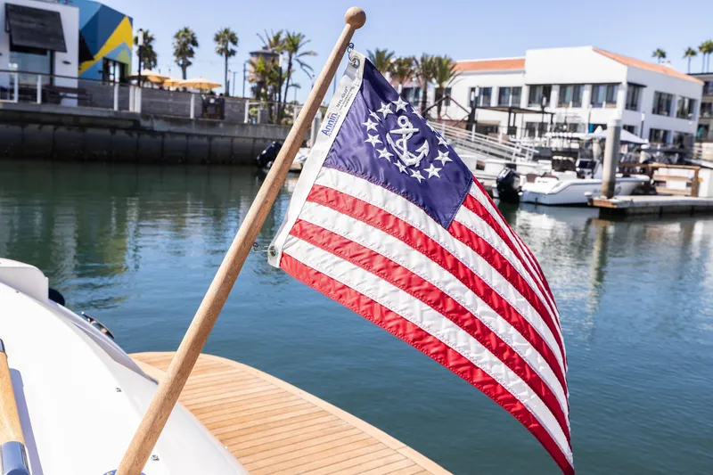 Slide: The Image of 2007 Chris Craft Corsair with nautical flag in marina setting. - 24