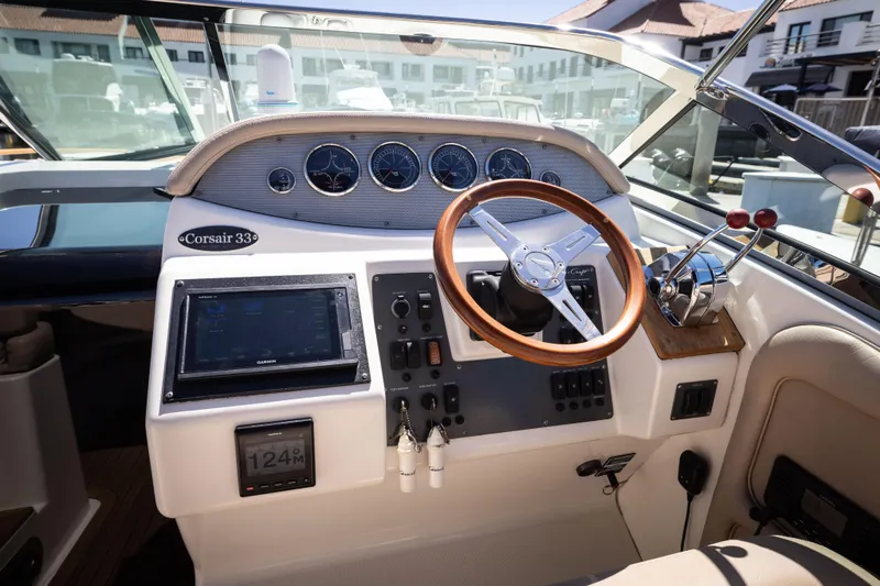 Slide: The Image of 2007 Chris Craft Corsair boat dashboard with wooden steering wheel and control panel. - 3