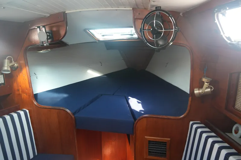 Slide: The Image of Cozy cabin interior of 1987 Ericson 32-200 sailboat with blue cushions and wood paneling. - 13