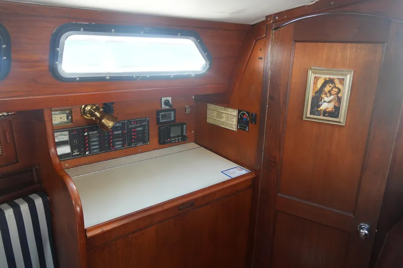 Slide: The Image of Interior of 1987 Ericson 32-200 sailboat with navigation station and religious artwork. - 17