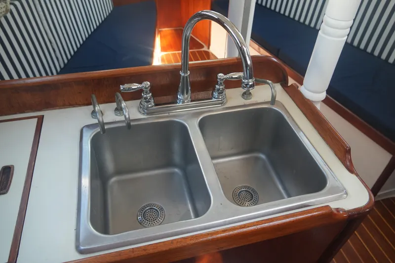 Slide: The Image of Stainless steel double sink in 1987 Ericson 32-200 yacht galley with striped seating. - 21