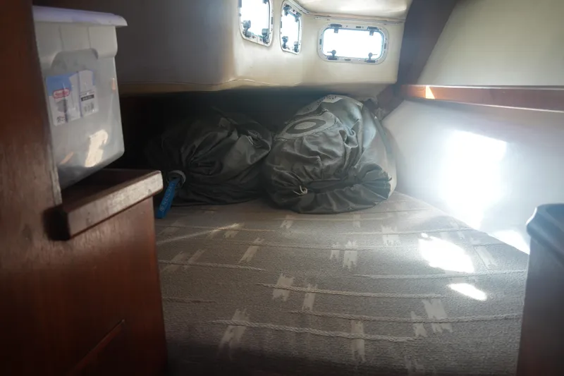 Slide: The Image of Cozy cabin interior of 1987 Ericson 32-200 sailboat with storage and portholes. - 25