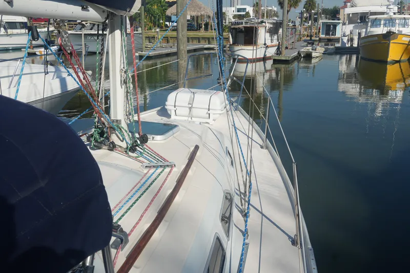 Slide: The Image of 1987 Ericson 32-200 sailboat docked in a marina, surrounded by other boats. - 7