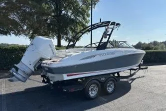 Slide: The Image of 2023 Tahoe 210 S boat on trailer, parked outdoors under clear sky. - 3