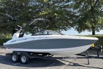 Slide: The Image of 2023 Tahoe 210 S boat on trailer, parked outdoors with trees in background. - 6