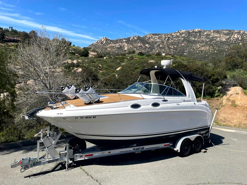 The Image of 2004 Sea Ray 260 Sundancer boat on trailer, scenic mountain backdrop. - 0