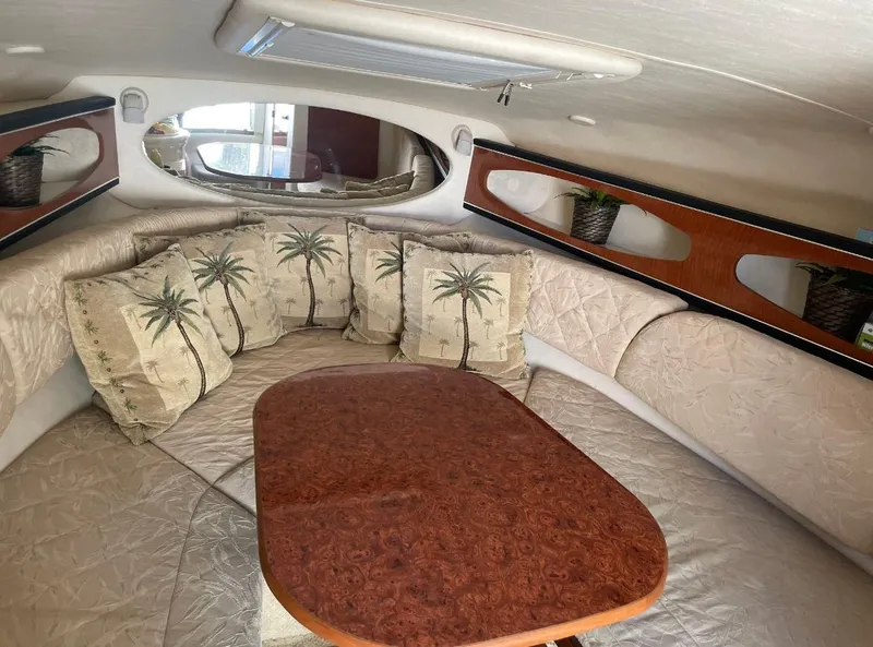 Slide: The Image of Interior of 2004 Sea Ray 260 Sundancer with cushioned seating and decorative pillows. - 10