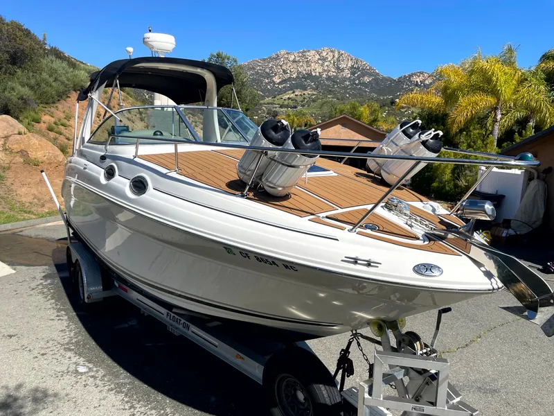Slide: The Image of 2004 Sea Ray 260 Sundancer boat on trailer, scenic mountain backdrop, sunny day. - 6