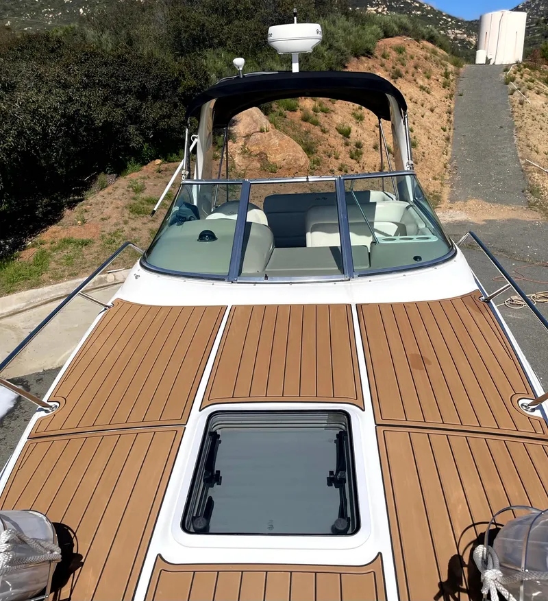 Slide: The Image of 2004 Sea Ray 260 Sundancer boat with teak deck, docked in a scenic outdoor setting. - 7