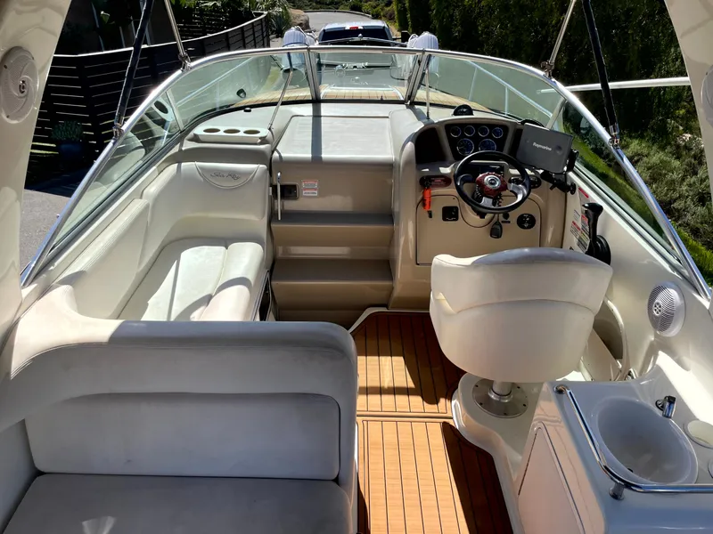 Slide: The Image of 2004 Sea Ray 260 Sundancer boat interior with helm, seating, and wooden flooring. - 8
