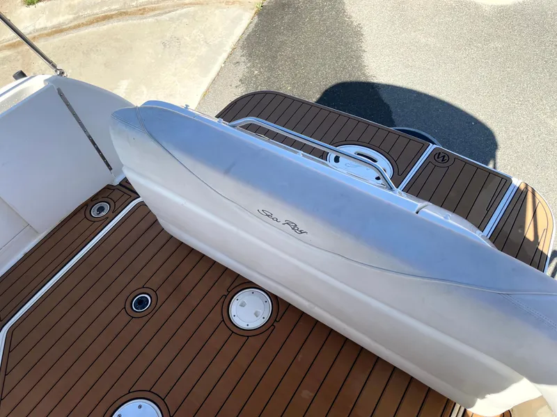 Slide: The Image of 2004 Sea Ray 260 Sundancer boat deck with teak flooring and white seating. - 9