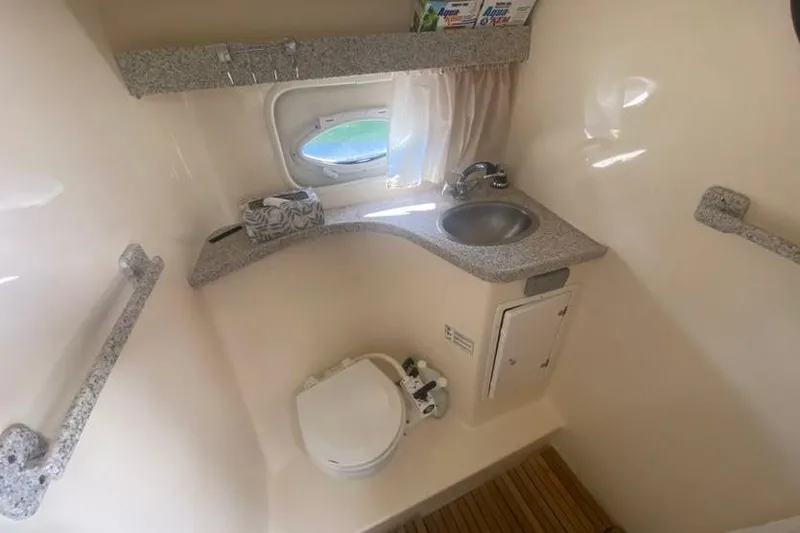 Slide: The Image of 2001 Rinker 310 Fiesta Vee boat bathroom with sink, toilet, and window. - 10