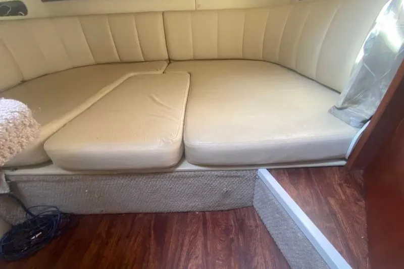 Slide: The Image of 2001 Rinker 310 Fiesta Vee interior with beige seating and wooden flooring. - 11