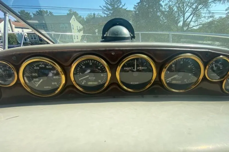 Slide: The Image of Dashboard of a 2001 Rinker 310 Fiesta Vee boat with gauges and compass. - 16