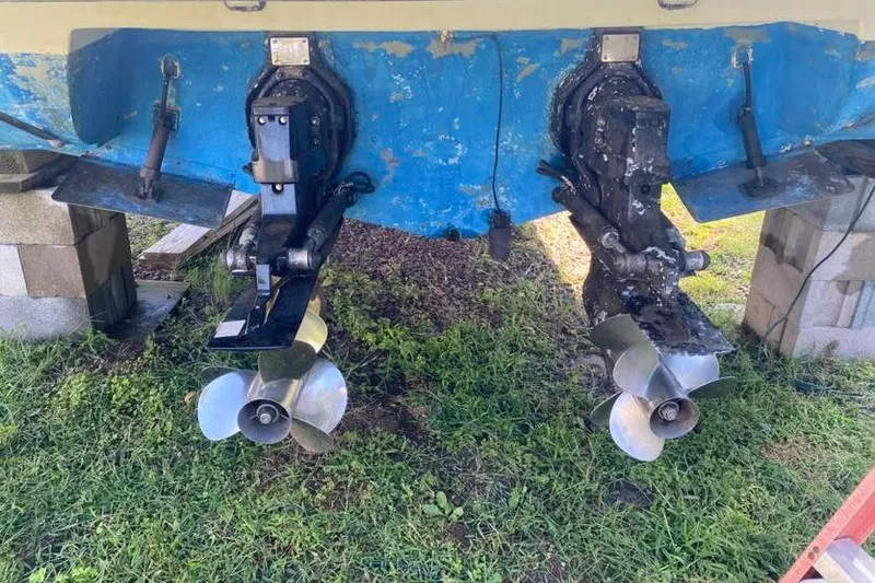 Slide: The Image of 2001 Rinker 310 Fiesta Vee boat propellers and stern drive on grass. - 20