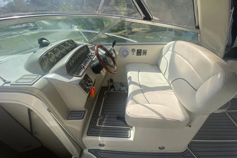 Slide: The Image of 2001 Rinker 310 Fiesta Vee boat interior with steering wheel and white seating. - 8