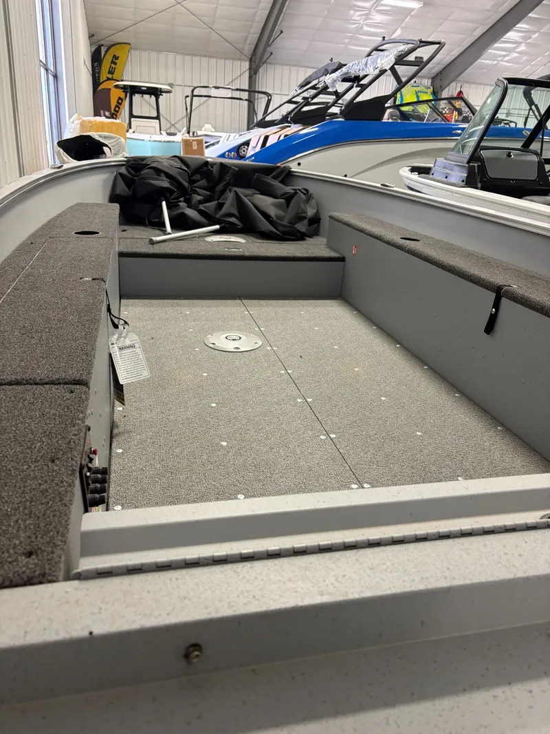 Slide: The Image of Interior view of Lund 1400 Fury Tiller 2025 boat in showroom. - 11