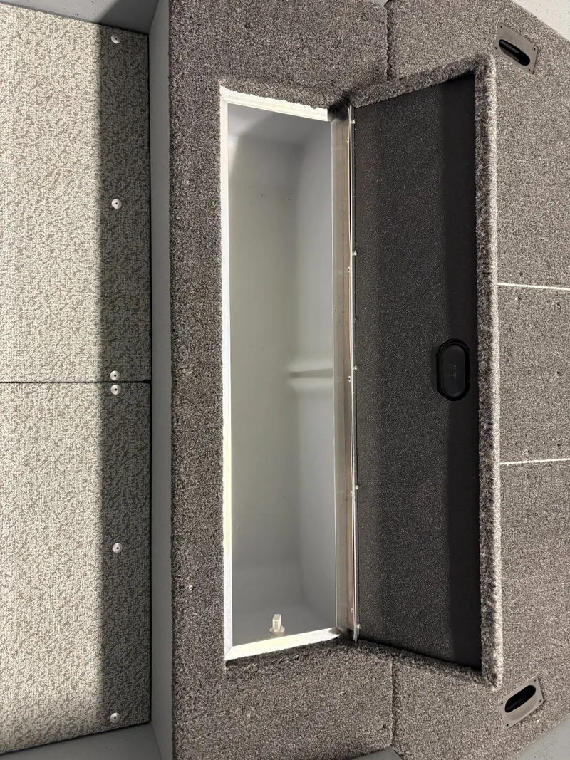 Slide: The Image of Open storage compartment in Lund 1400 Fury Tiller 2025 boat. - 3