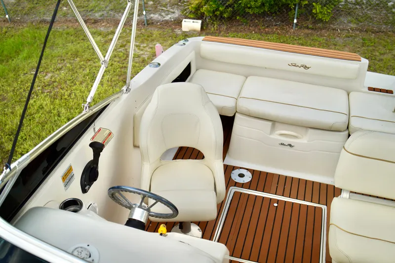 Slide: The Image of 2001 Sea Ray 215 Express Cruiser on trailer, parked on grass with trees in background. - 0