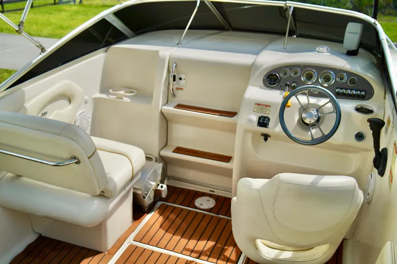 Slide: The Image of 2001 Sea Ray 215 Express Cruiser interior with steering wheel and seating, featuring wood accents. - 10