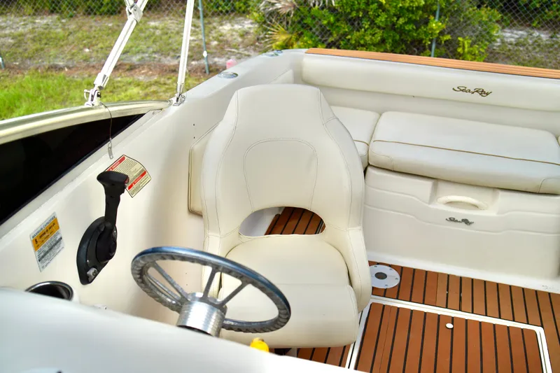 Slide: The Image of 2001 Sea Ray 215 Express Cruiser interior with white seating and wood accents. - 14
