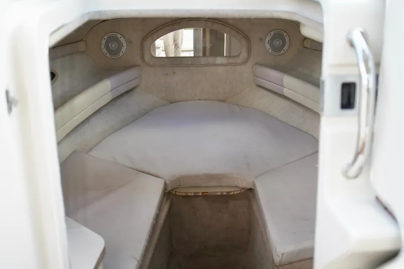 Slide: The Image of 2001 Sea Ray 215 Express Cruiser cabin interior with cushioned seating and speakers. - 17