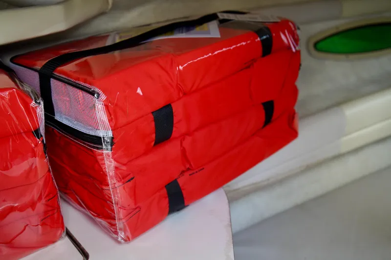 Slide: The Image of Red life jackets stored on a 2001 Sea Ray 215 Express Cruiser boat. - 18