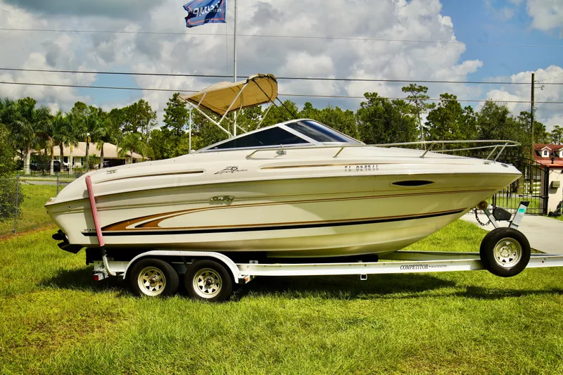 Slide: The Image of 2001 Sea Ray 215 Express Cruiser interior with white seating and wood accents. - 7